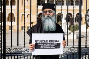 feature gina demonstration outside the arhcbishopric with a protester dressed up as morphou bish neophytos