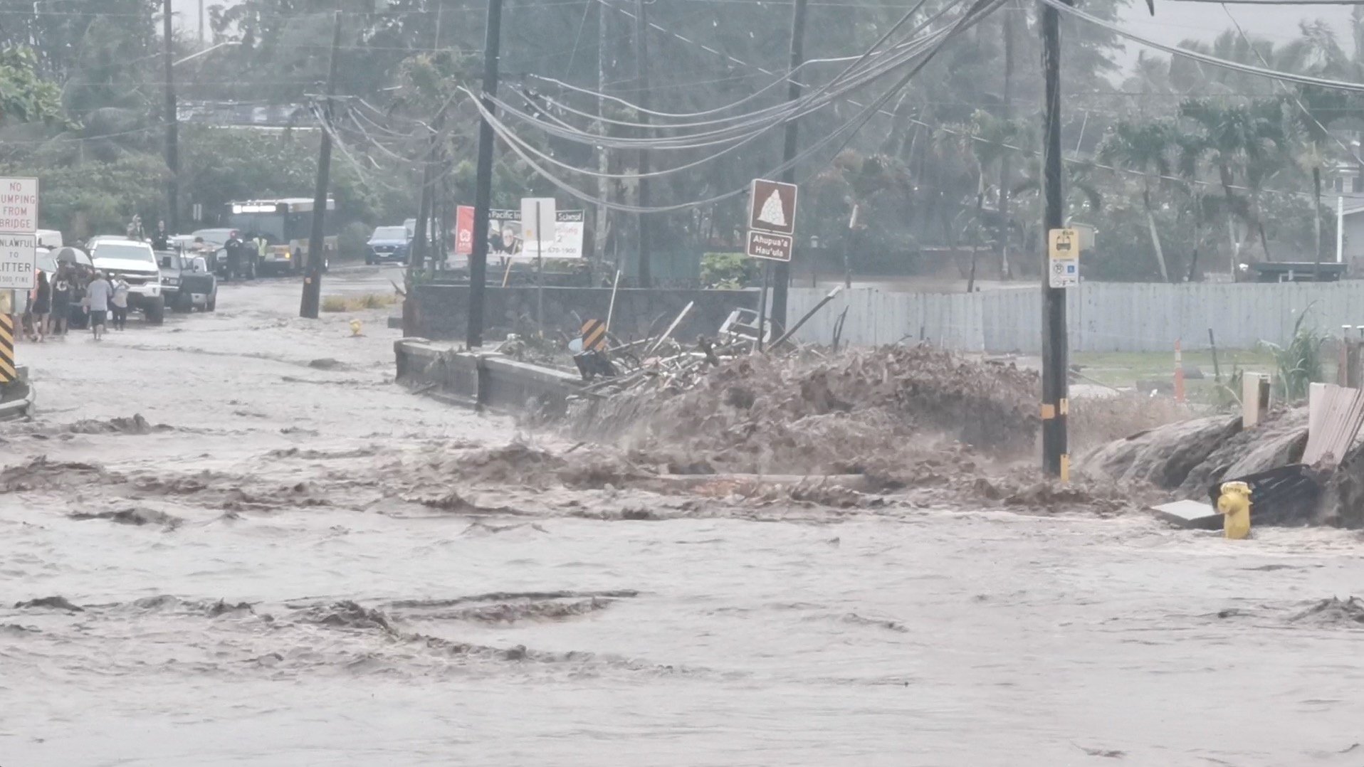 social media video grab shows floodwaters streaming down a street in hauula, hawaii