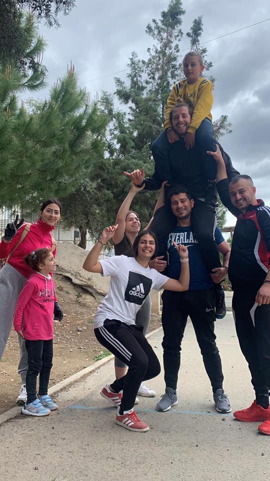 marios polymiou carrying yiannis pepetsios on his shoulders with a group of volunteers