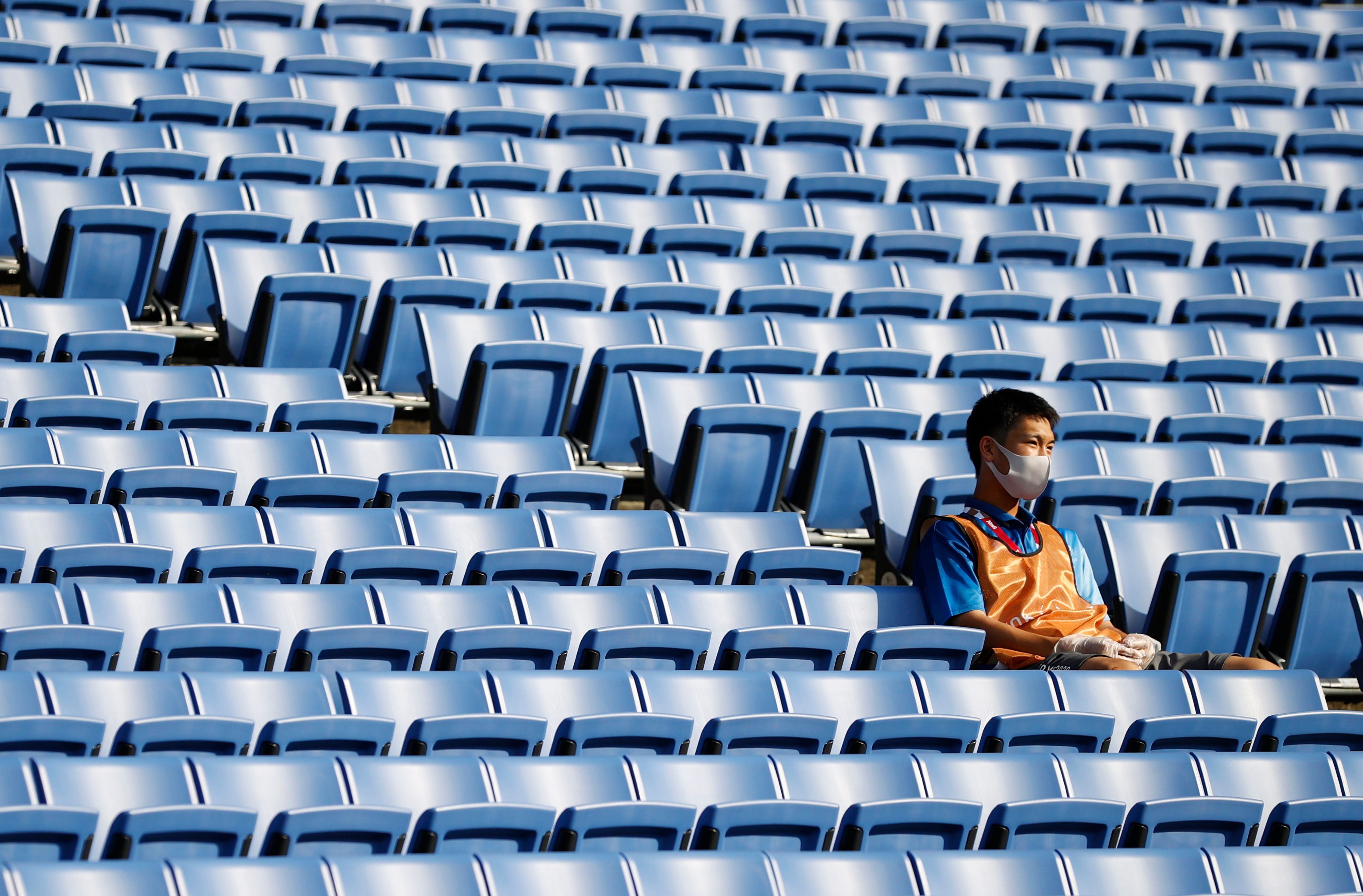 image Olympics-All dressed up with no one to help, Tokyo volunteers sit in for spectators