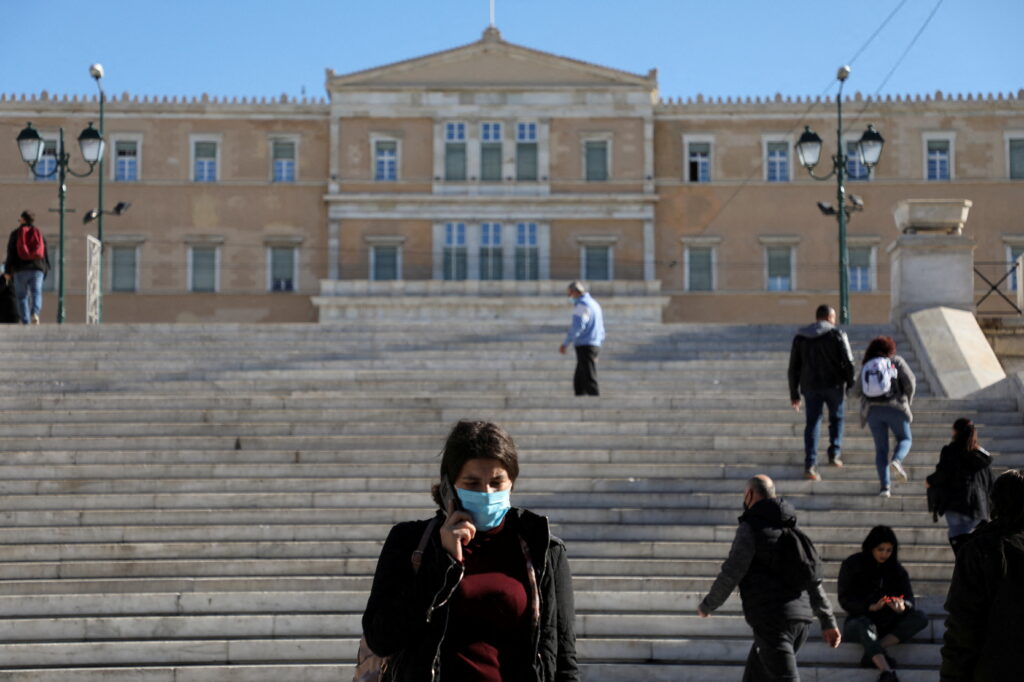 file photo: people wearing protective face masks against covid 19 walk in syntagma square in athens, greece