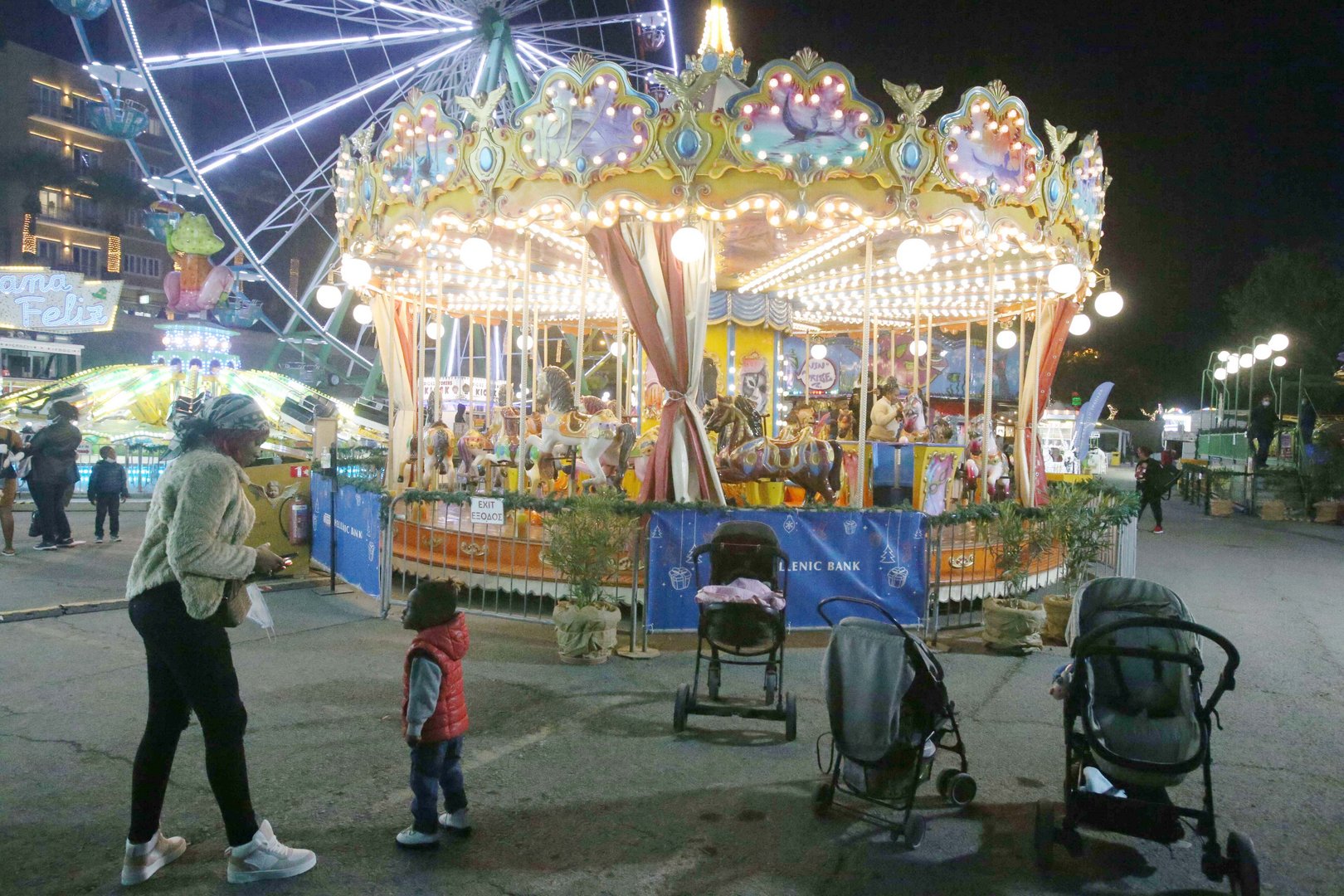 feature nick a small child looks expectantly at his mother in front of the carousel