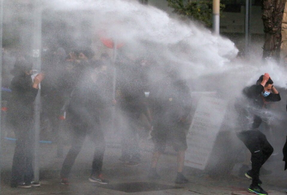 the police using a water cannon at a febbruary demo