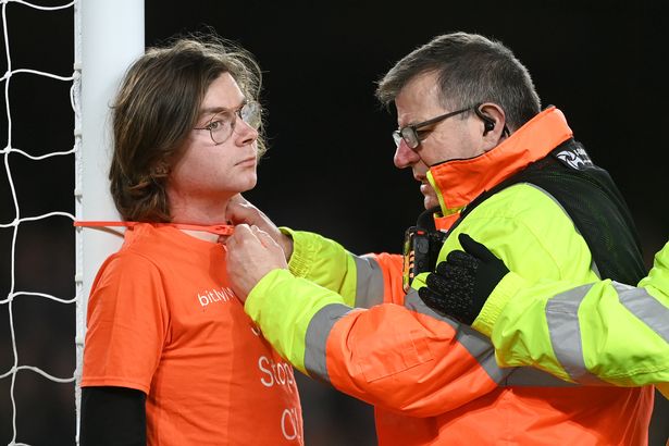 image Oil protestor ties himself to goal post at Premier League fixture