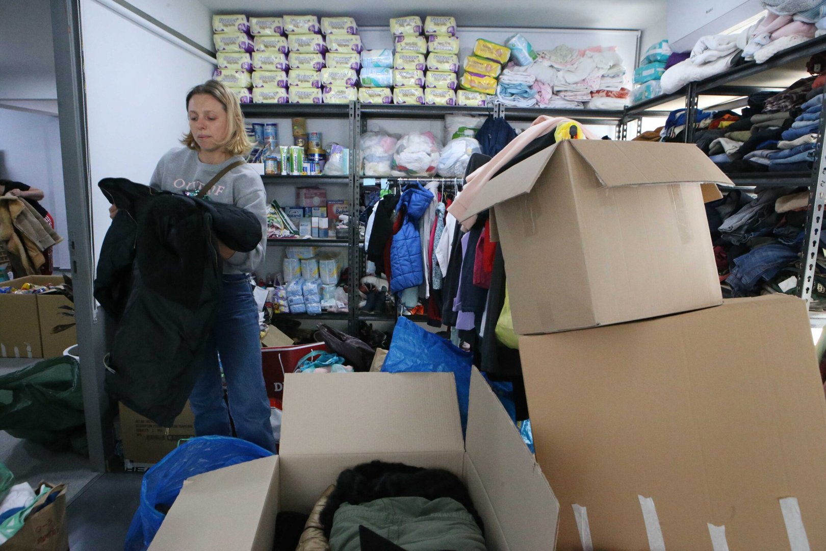 feature chris zina sorts through clothes as she helps out at cy4ua in larnaca (christos theodorides)