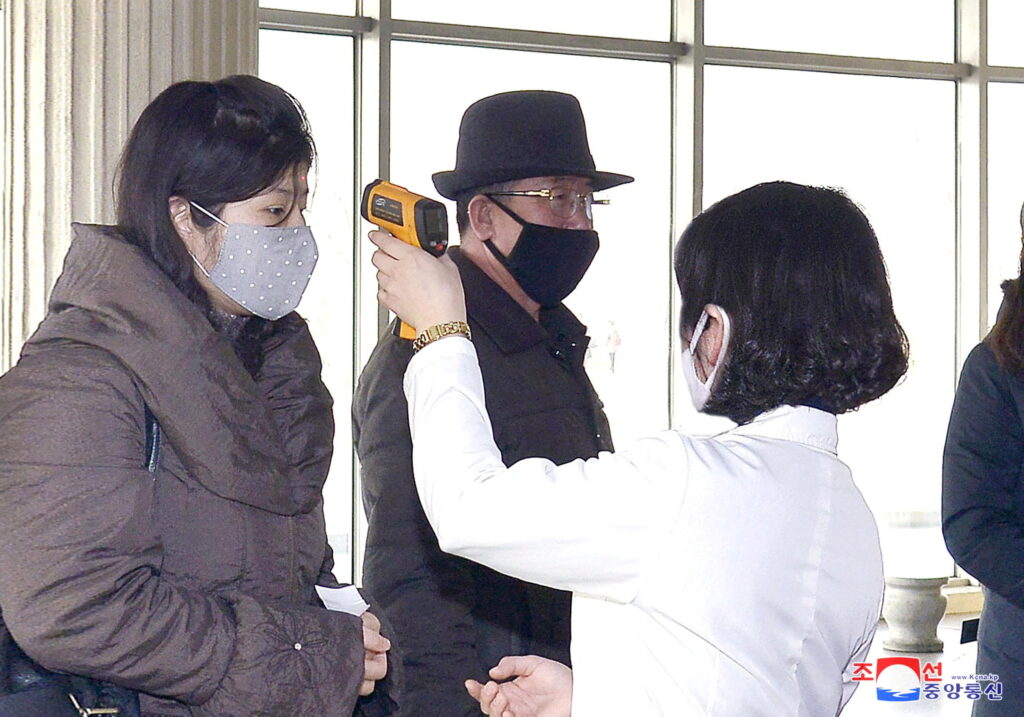 file photo: file photo: kcna picture of volunteers carrying out temperature screening during an anti virus campaign in pyongyang