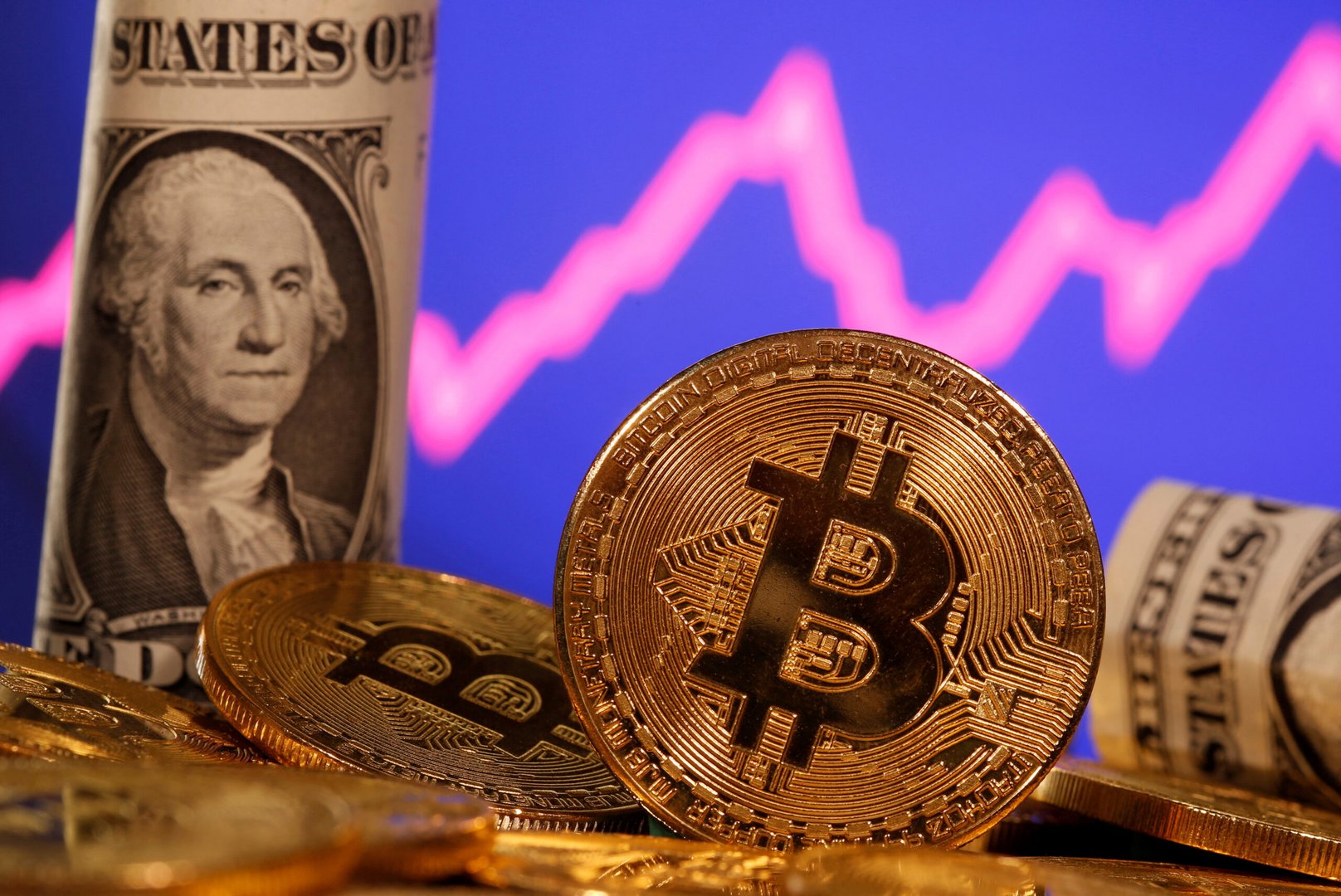 file photo: a representation of virtual currency bitcoin and a u.s. one dollar banknote are seen in front of a stock graph in this illustration