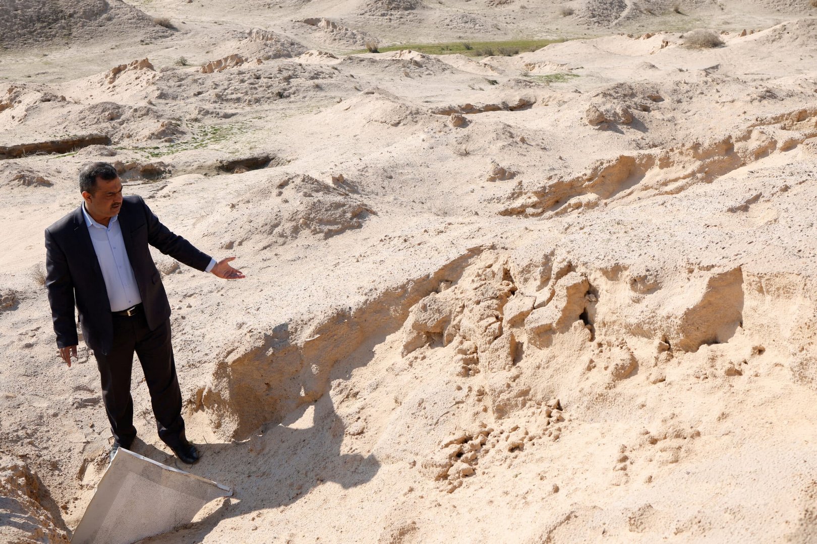 iraqi engineer hazem mohammed walks on the site of an unearthed mass grave on the outskirts of the city of najaf