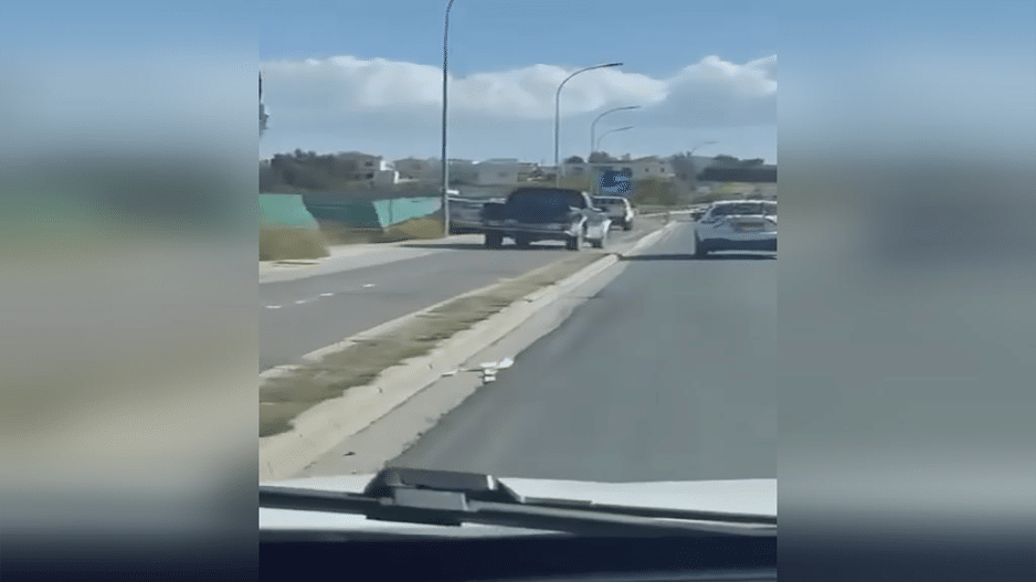 image Two pickup trucks drive down cycle lane