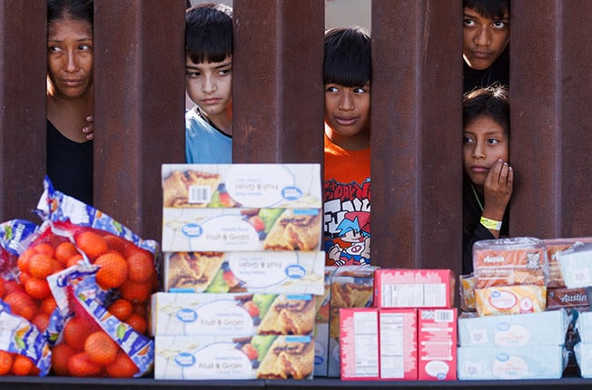 image Migrants &#8216;from all over the globe&#8217; gather between California border barriers