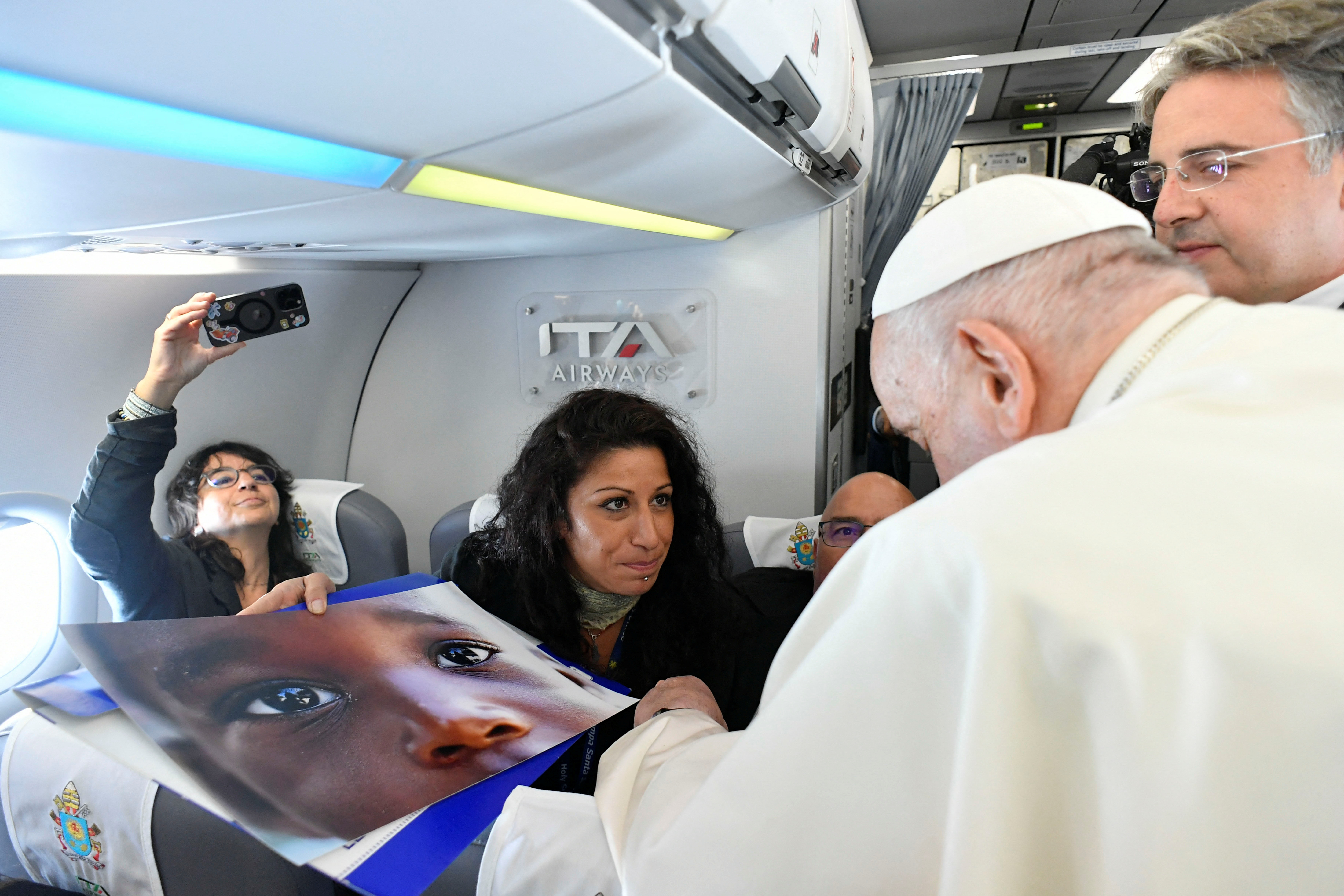 image Pope Francis moved as Reuters photographer shows him child migrant picture