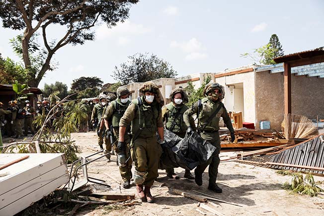 image Bodies lie in the grounds of ravaged Israeli kibbutz