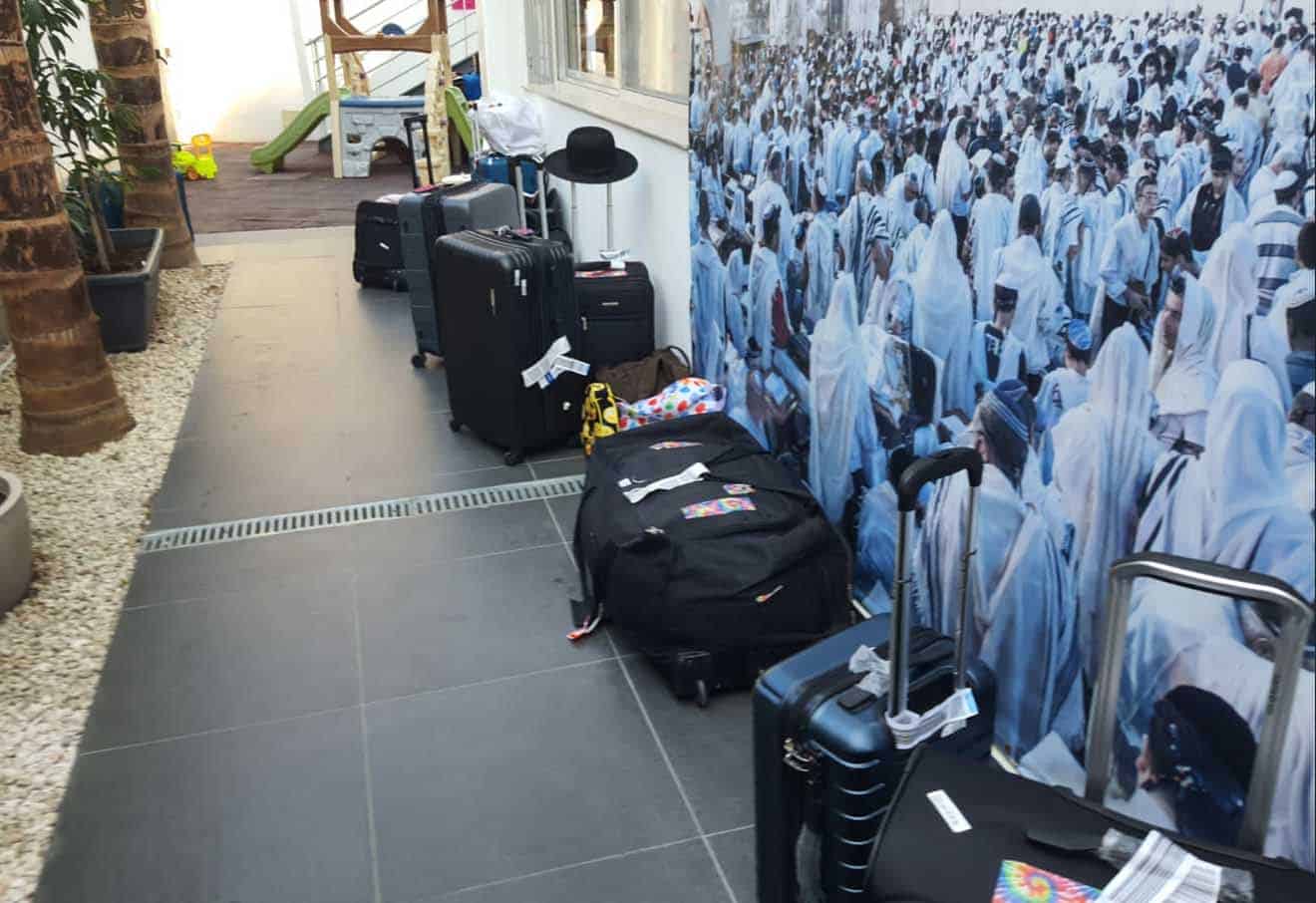 feature andria suitcases of fleeing israelis lined up outisde the synagogue in larnaca