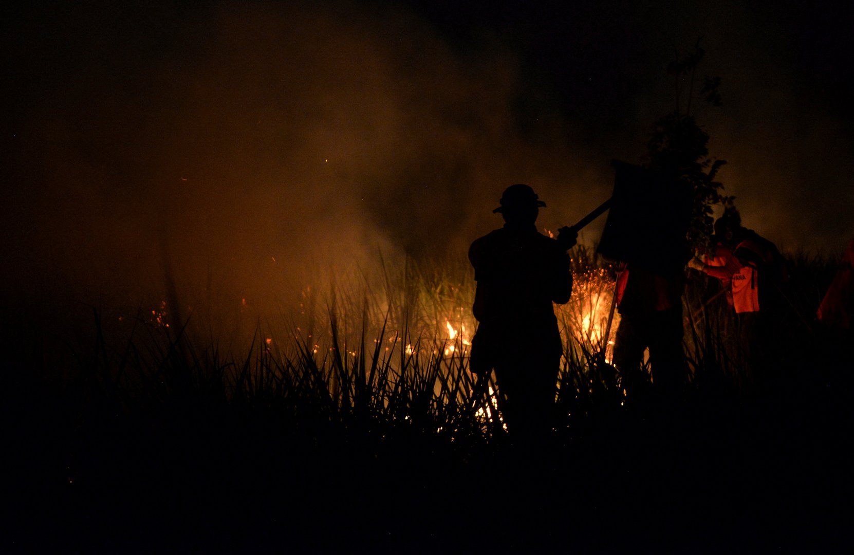 image Bolivians use hoses, water bottles to battle wildfire blazes