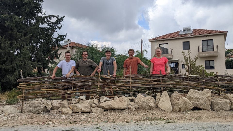 german forestry students from saxony building a 'natural fence' around a community tree planting project