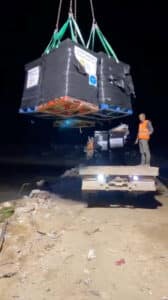 workers unload aid packages from a ship arriving from cyprus at the gaza coast