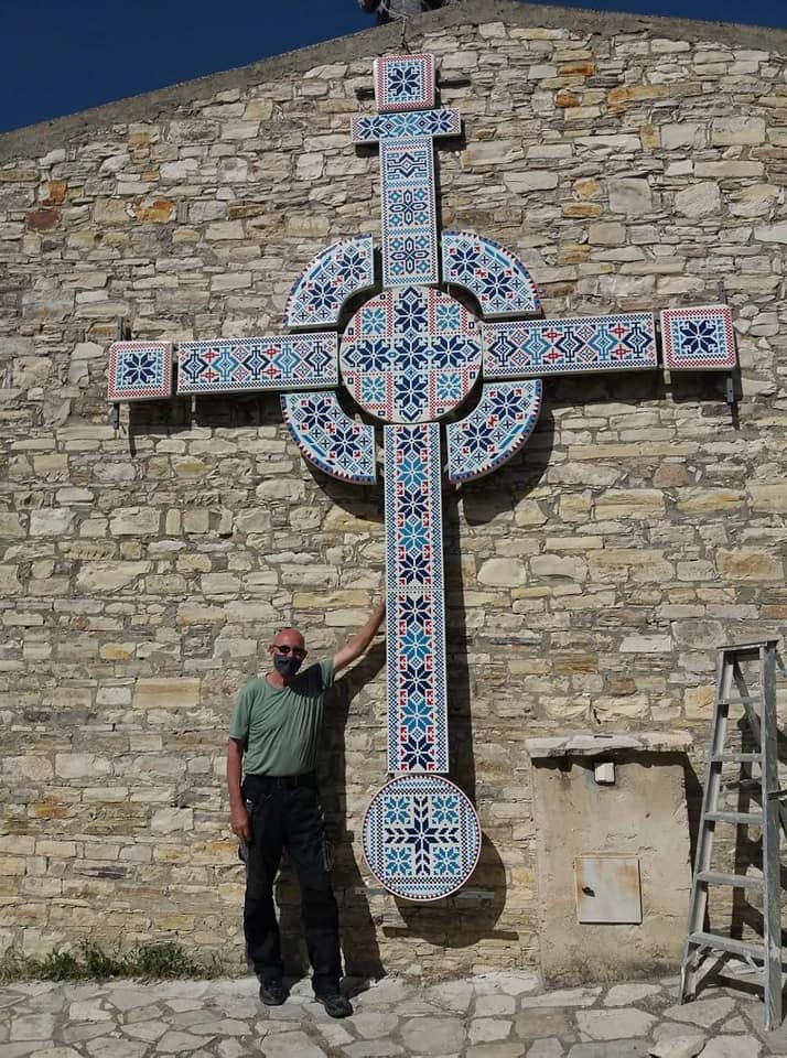 peter bird with a cross he made at the bee and embroidery museum in kato drys is helping to keep 'lekara lace' alive but is made from thrown away tables, shelves and chair seats